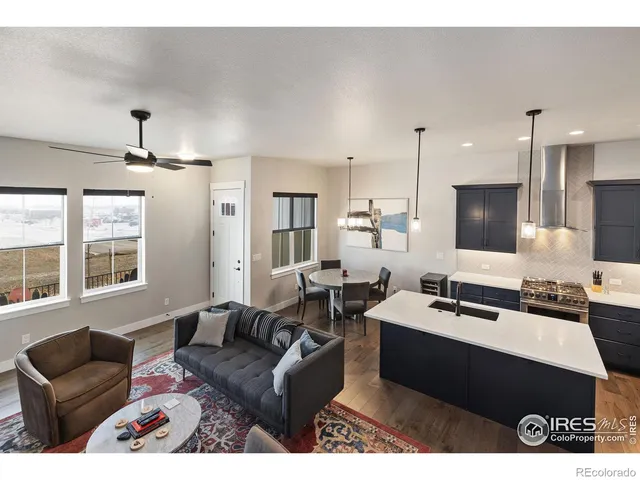 a living room with furniture kitchen view and a large window
