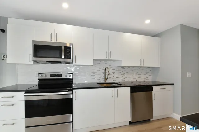 a view of an empty room with a fireplace and a window