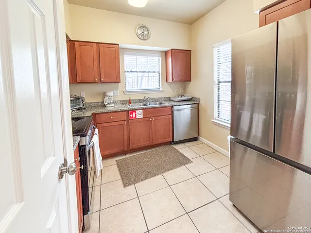 a kitchen with stainless steel appliances granite countertop a refrigerator and a sink
