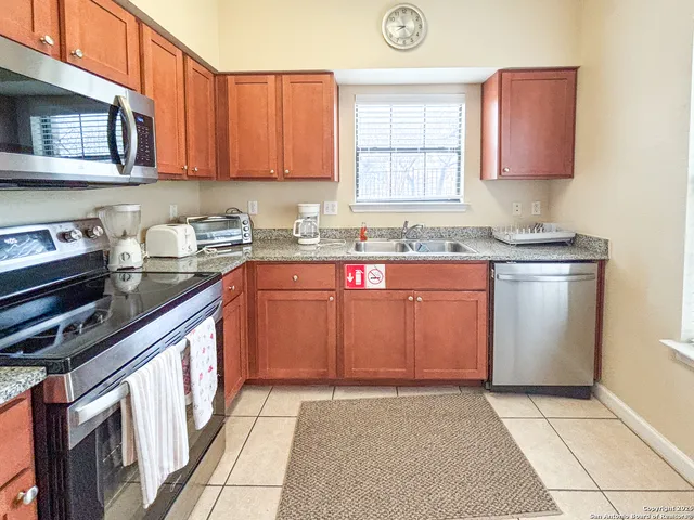 a kitchen with a sink stove top oven and cabinets