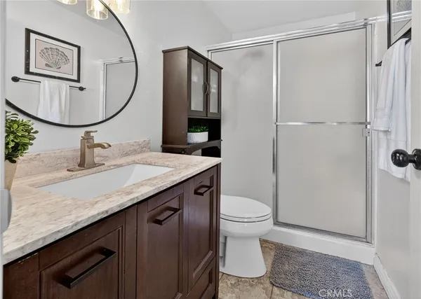 a bathroom with a granite countertop sink toilet and a mirror