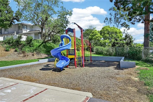 a view of house with backyard and a slide