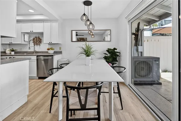 a view of a dining room with furniture a kitchen and chandelier