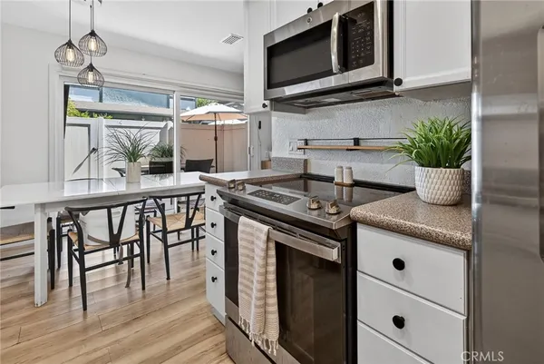 a kitchen with stainless steel appliances granite countertop a stove a microwave and a wooden floors