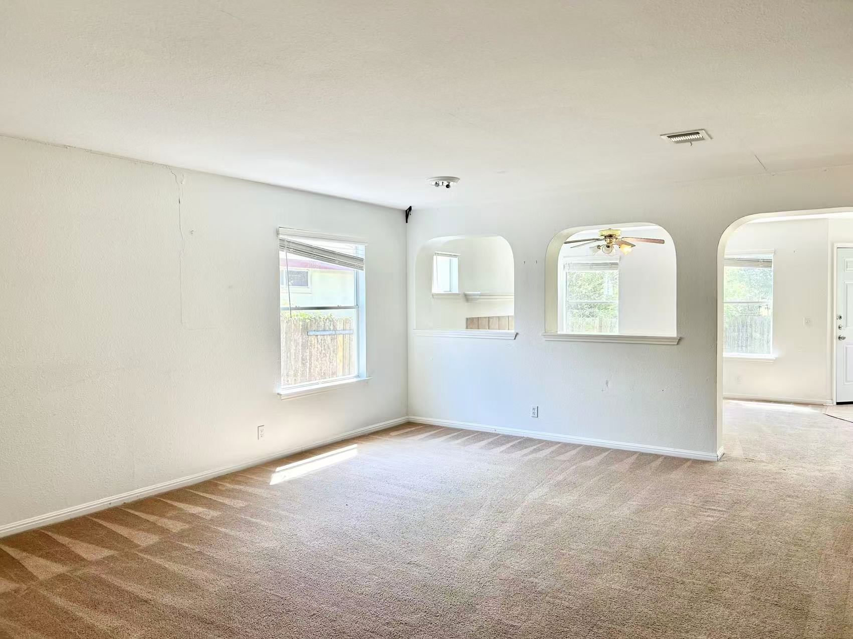 5608 Netleaf Road Austin, TX 78724 - Photo 7 of 26 Sun-drenched living area featuring plush carpeting and architectural arched openings.