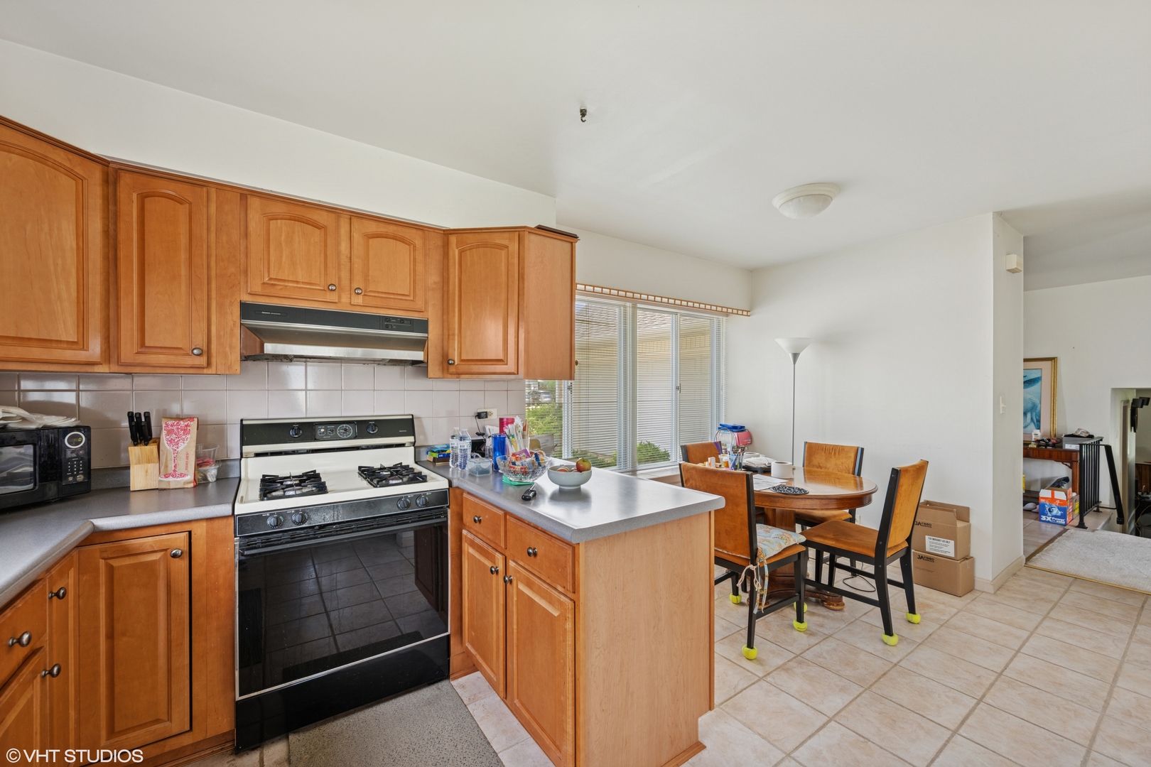 795 Hunter Drive Roselle, IL 60172 - Photo 6 of 26 a kitchen with stainless steel appliances granite countertop a stove top oven a sink dishwasher and chairs with wooden cabinets