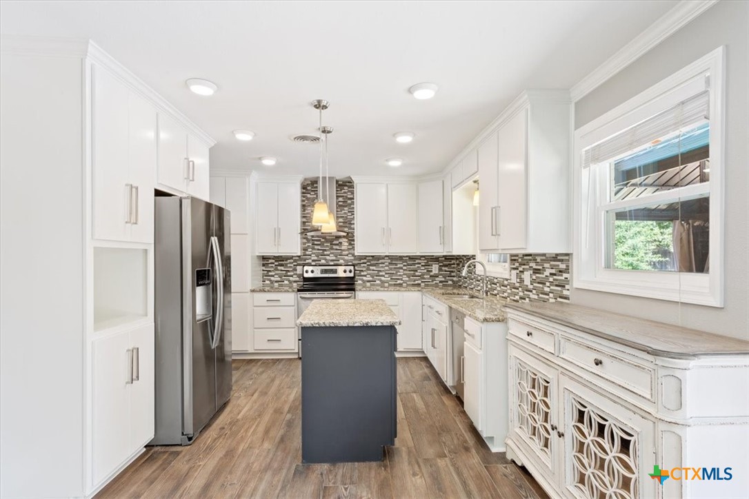 2810 Lilac Lane Temple, TX 76502 - Photo 11 of 40 a kitchen with stainless steel appliances granite countertop a refrigerator a sink dishwasher a stove and white countertops with wooden floor