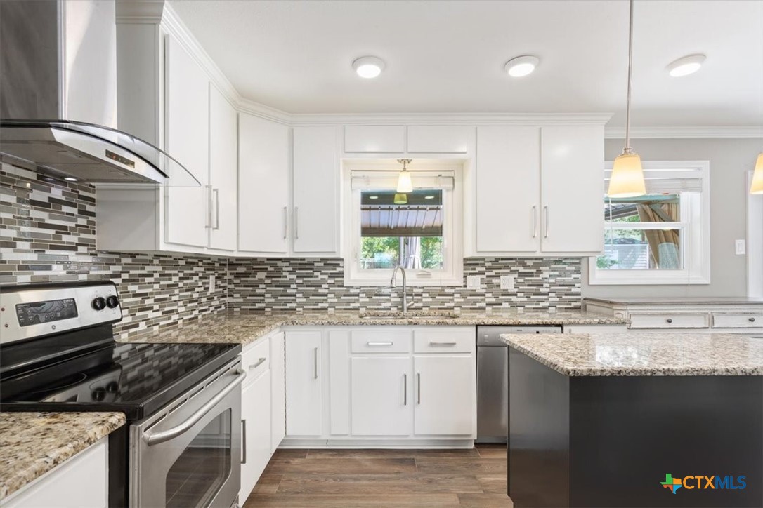 2810 Lilac Lane Temple, TX 76502 - Photo 14 of 40 a kitchen with granite countertop a sink stove and cabinets