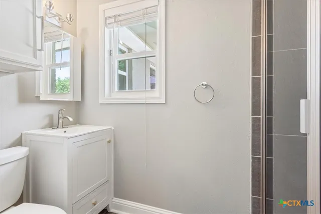 a bathroom with a sink toilet and window