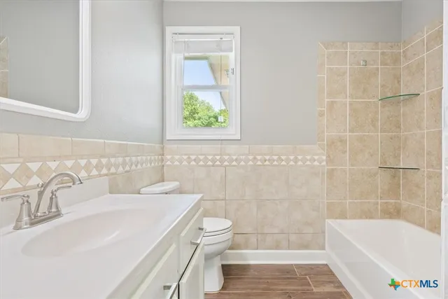 a bathroom with a sink a toilet a bathtub and shower