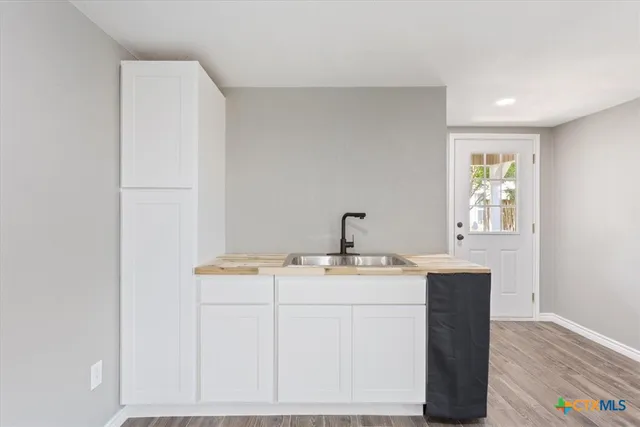 a view of empty room with wooden floor and window