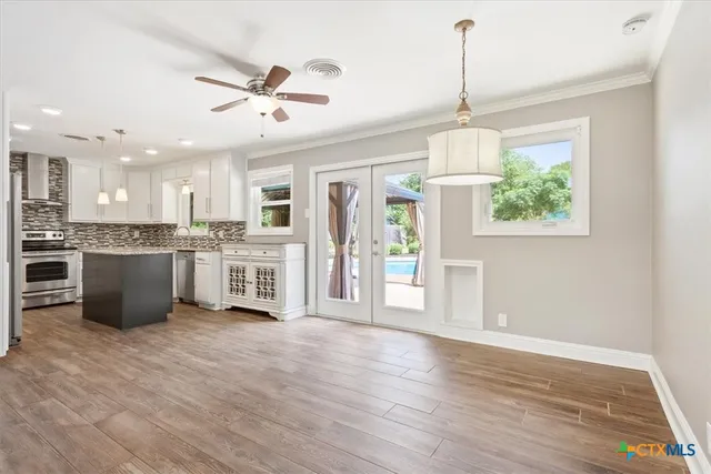 a view of a kitchen with wooden floor and a ceiling fan