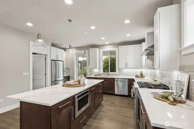 a kitchen with a counter top space a sink stainless steel appliances and cabinets