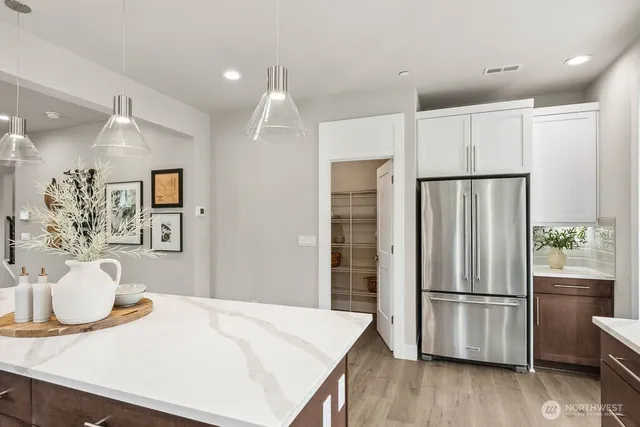 a kitchen with stainless steel appliances a refrigerator sink and wooden floor