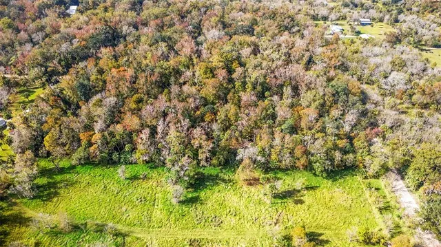 an aerial view of residential house with green space and fog