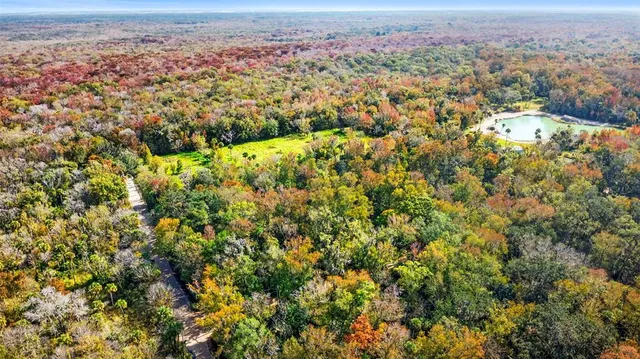 an aerial view of residential house with parking and yard