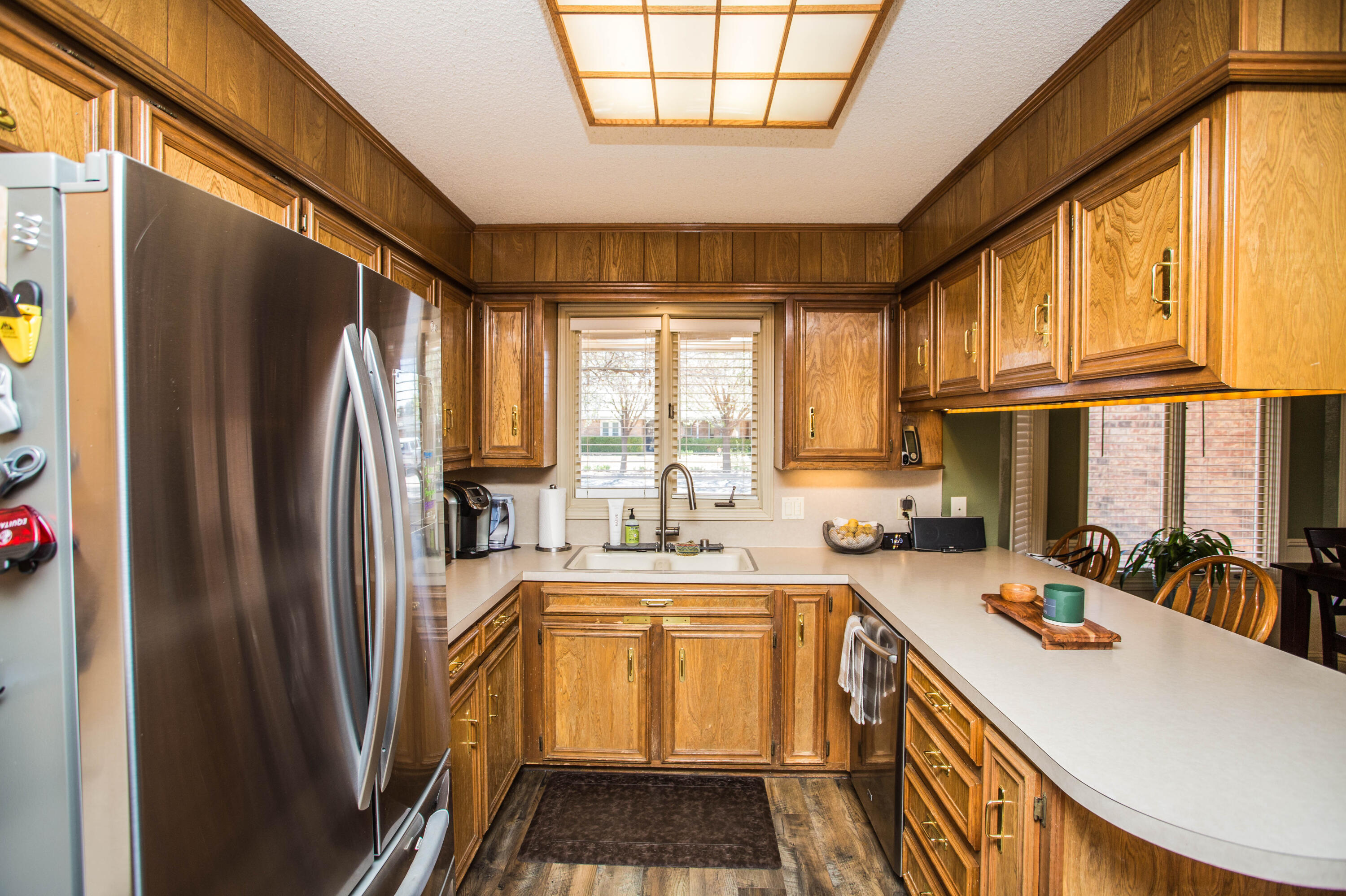 5202 85th Street Lubbock, TX 79424 - Photo 22 of 40 a kitchen with stainless steel appliances granite countertop a refrigerator a sink dishwasher a stove and a dining table with wooden floor