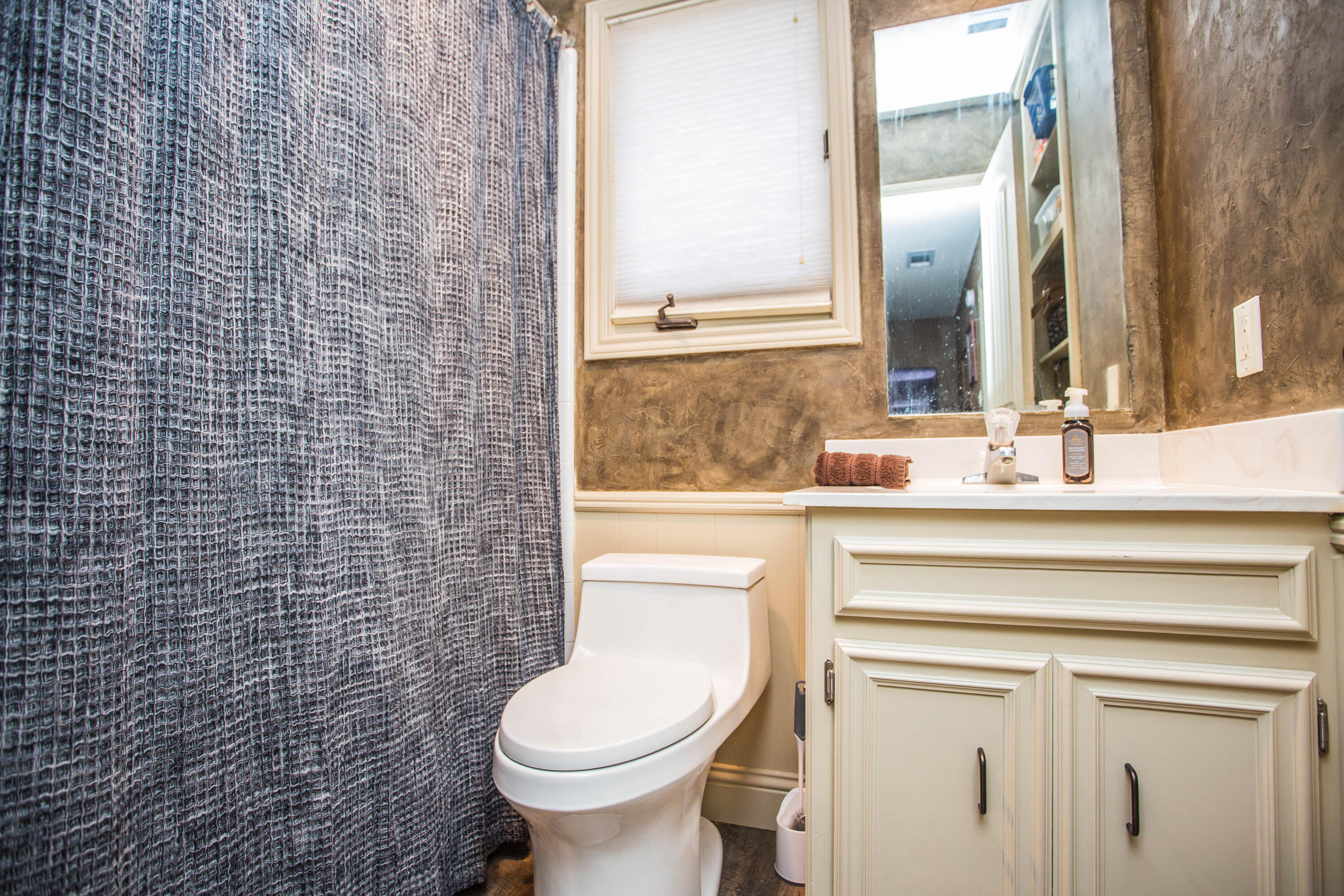 5202 85th Street Lubbock, TX 79424 - Photo 30 of 40 a bathroom with a sink a toilet and a mirror