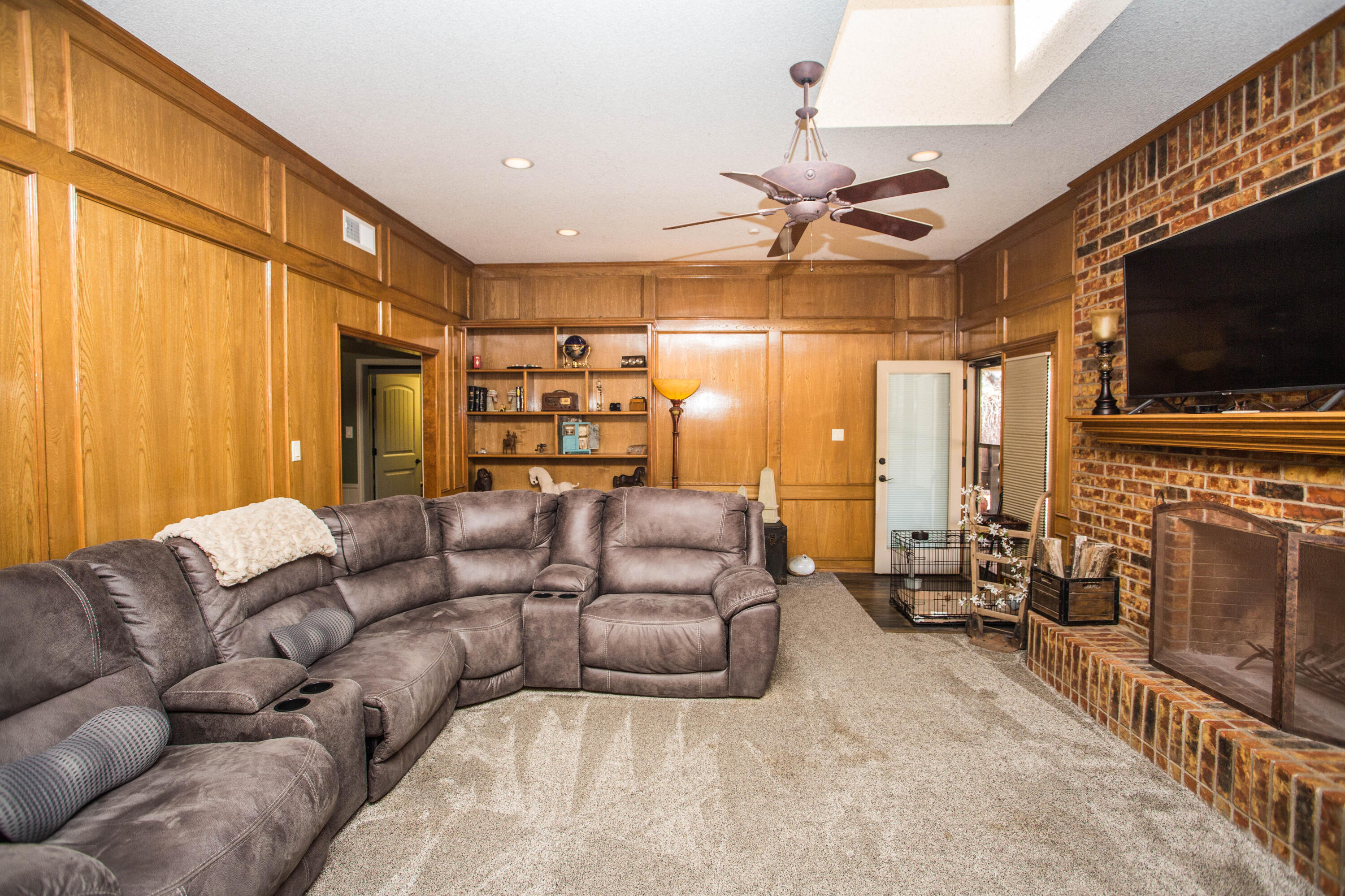 5202 85th Street Lubbock, TX 79424 - Photo 5 of 40 a living room with furniture a flat screen tv and a fireplace