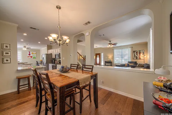 a dining room filled chandelier and wooden floor