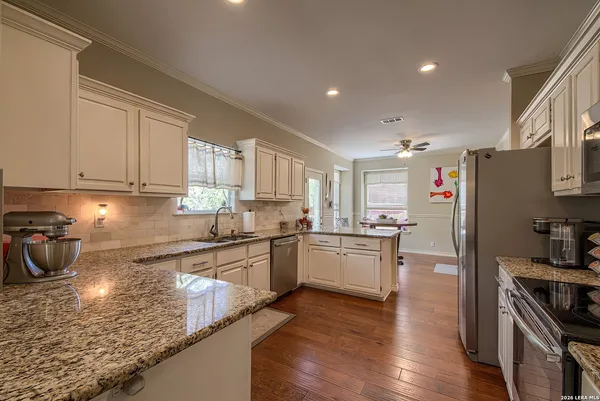 a kitchen with stainless steel appliances granite countertop a refrigerator stove top oven and sink