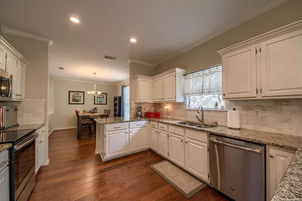 a kitchen with a sink white cabinets and appliances