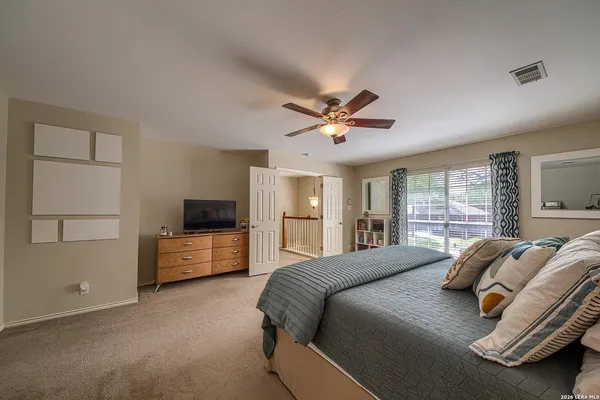 a bedroom with a large bed and windows