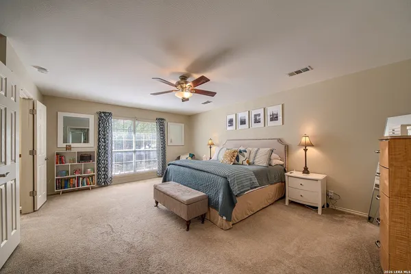 a spacious bedroom with a bed and a chandelier