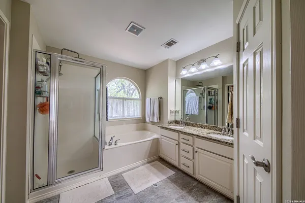 a large white bathroom with a large mirror a shower and a sink
