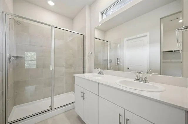 a bathroom with a shower sink and mirror