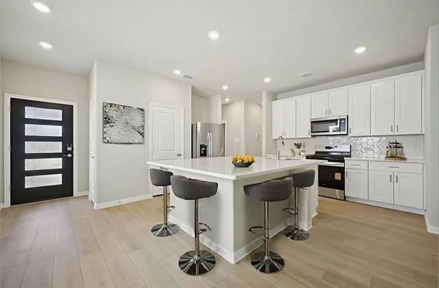 a kitchen with a sink a cabinets and wooden floor