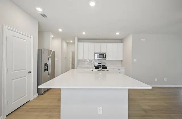 a kitchen with stainless steel appliances a refrigerator sink and microwave