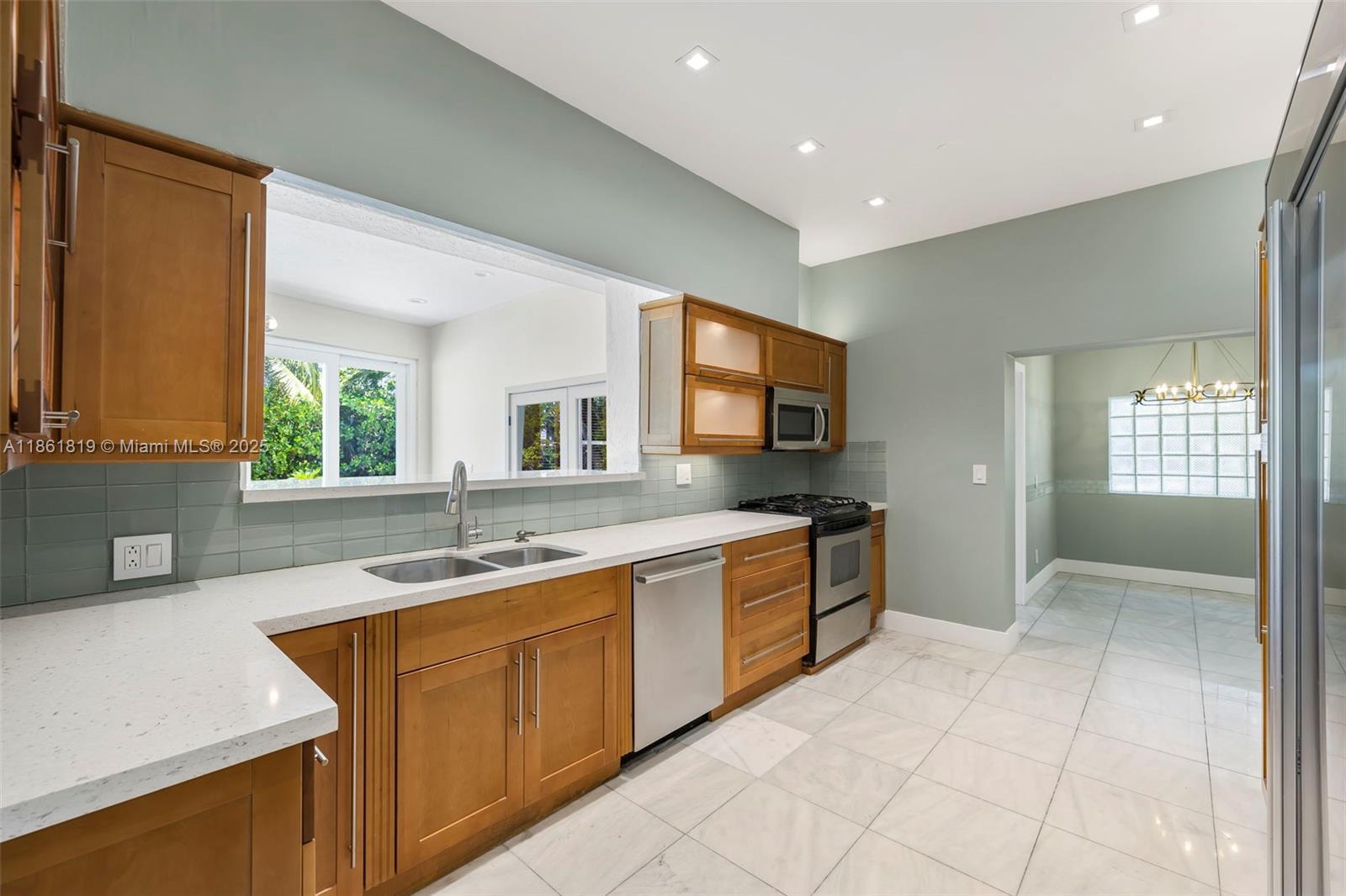 3180 North Bay Road Miami Beach, FL 33140 - Photo 14 of 41 a kitchen with a sink stove and cabinets