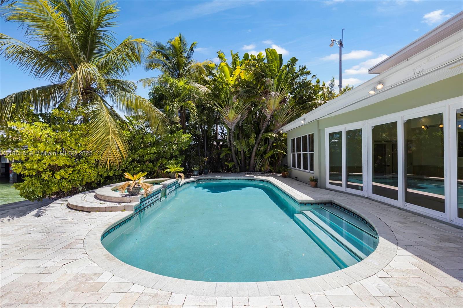 3180 North Bay Road Miami Beach, FL 33140 - Photo 32 of 41 a view of a swimming pool with a patio