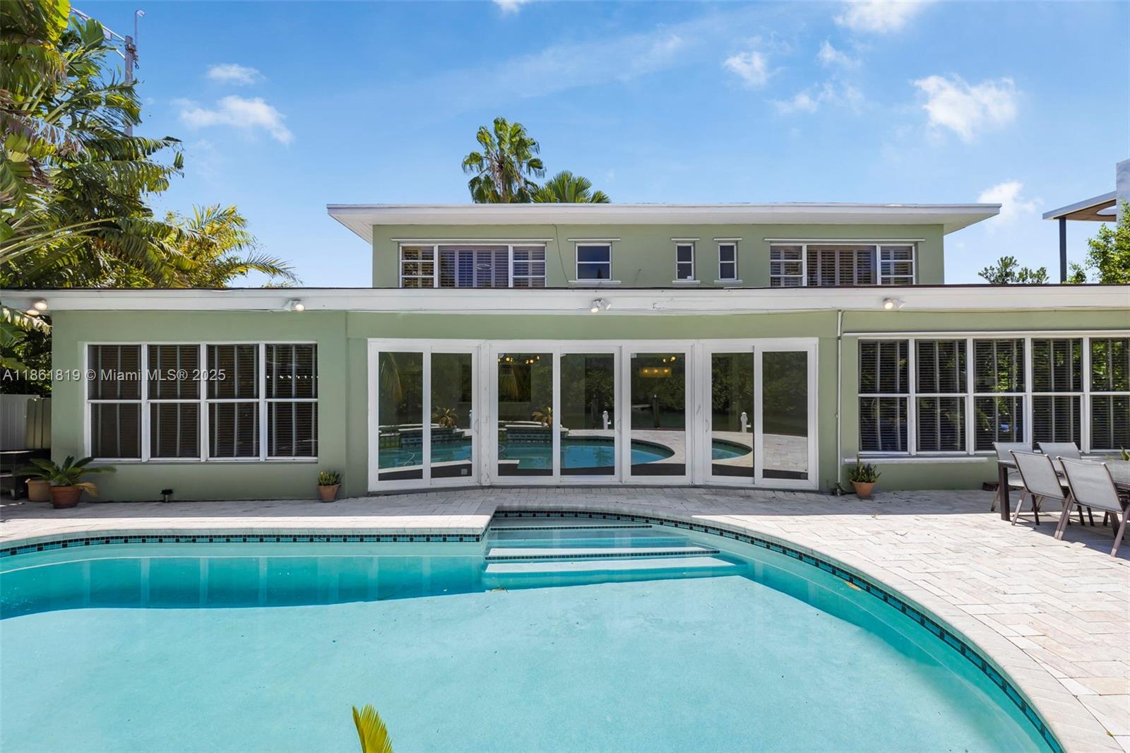 3180 North Bay Road Miami Beach, FL 33140 - Photo 34 of 41 a front view of a house with a yard fire pit and outdoor seating