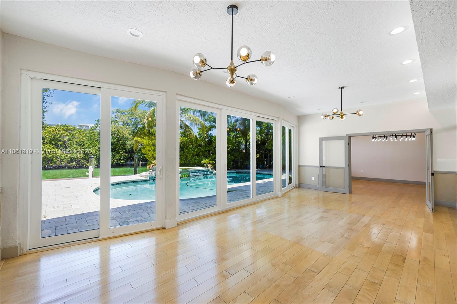 3180 North Bay Road Miami Beach, FL 33140 - Photo 10 of 41 a view of an empty room with a window and wooden floor