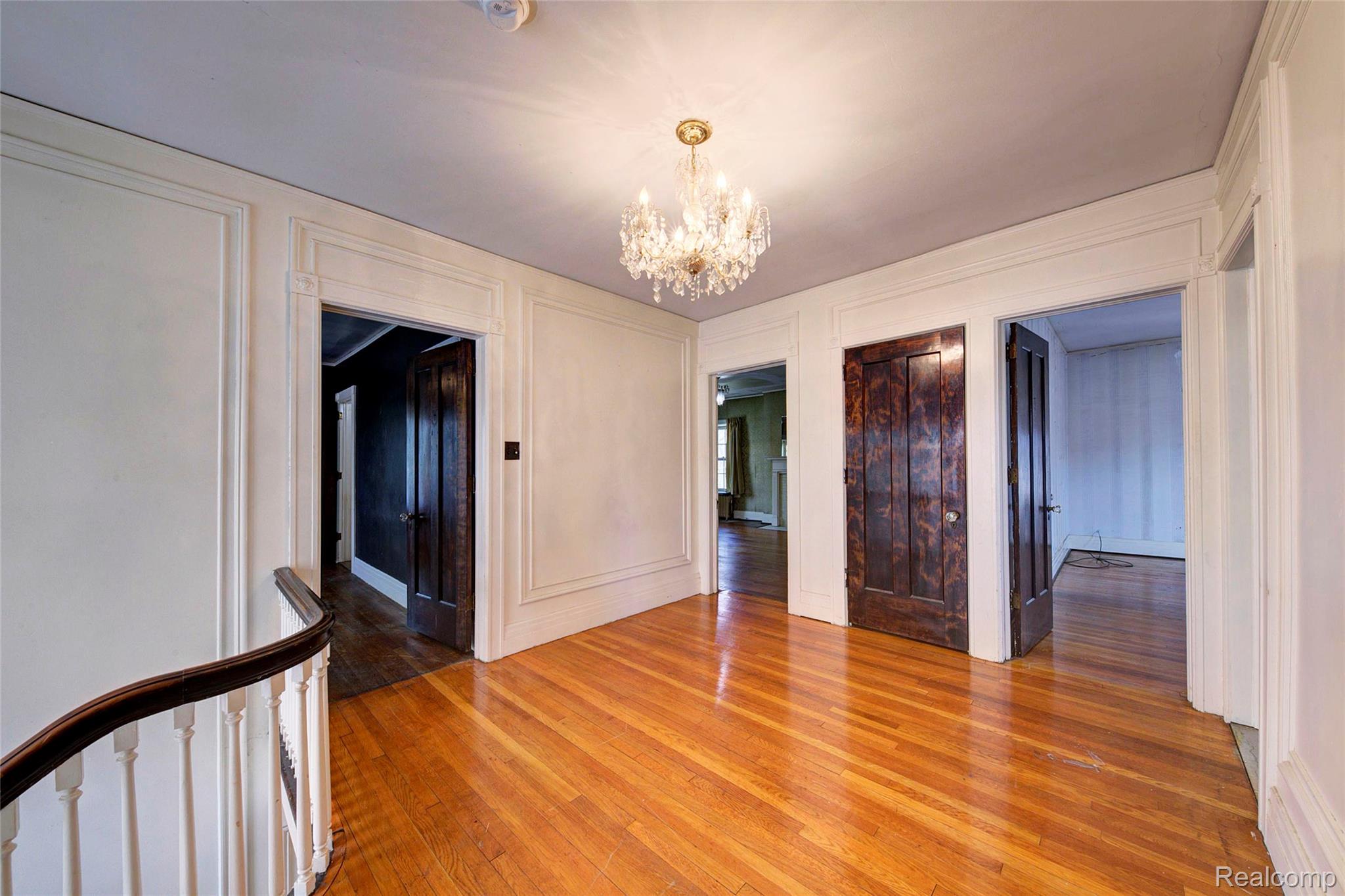 121 Longfellow Street Detroit, MI 48202 - Photo 35 of 87 Unfurnished dining area with a chandelier, hardwood / wood-style floors, and a decorative wall
