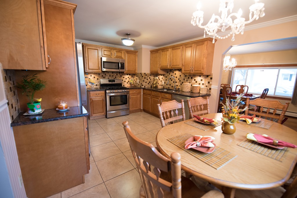 362 Stapleton Road Springfield, MA 01109 - Photo 6 of 24 a kitchen with stainless steel appliances granite countertop a stove a refrigerator a kitchen island a dining table and chairs with wooden floor
