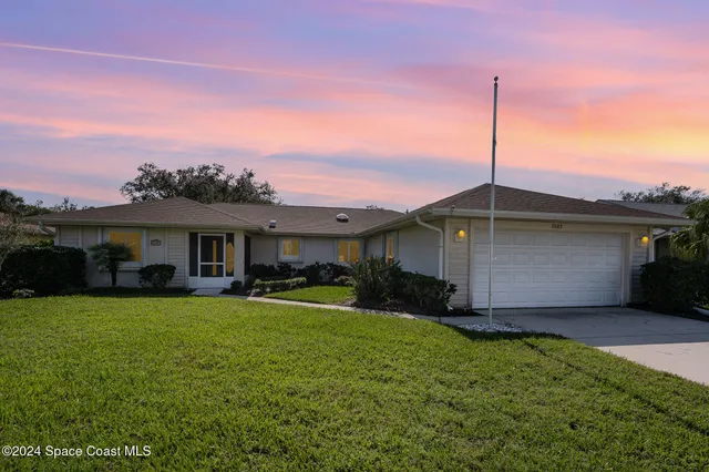 a front view of house with yard and garage