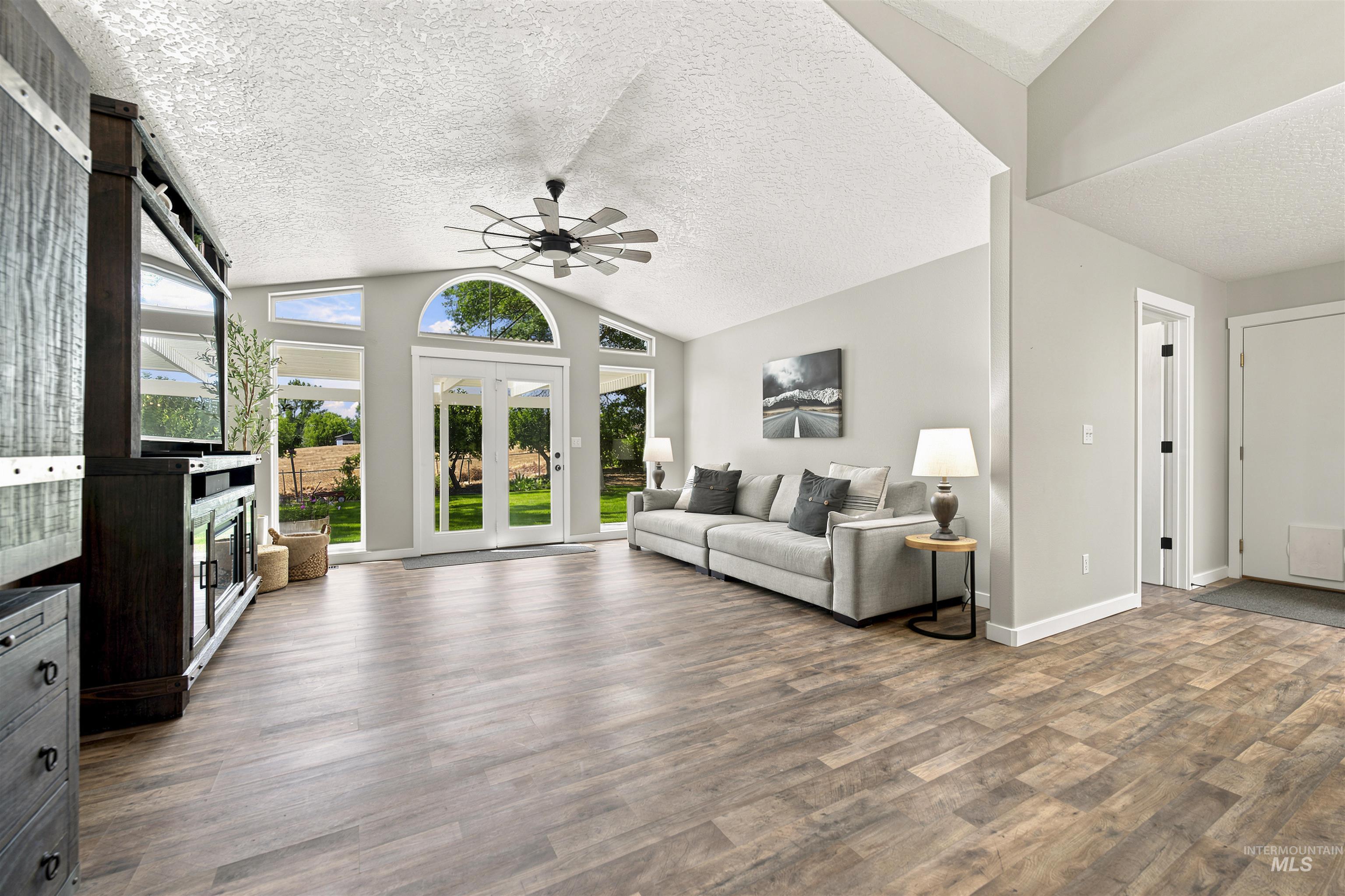 24864 Coventry Drive Caldwell, ID 83607 - Photo 6 of 49 Spacious living area featuring vaulted ceilings, wood-finish flooring, and multiple windows