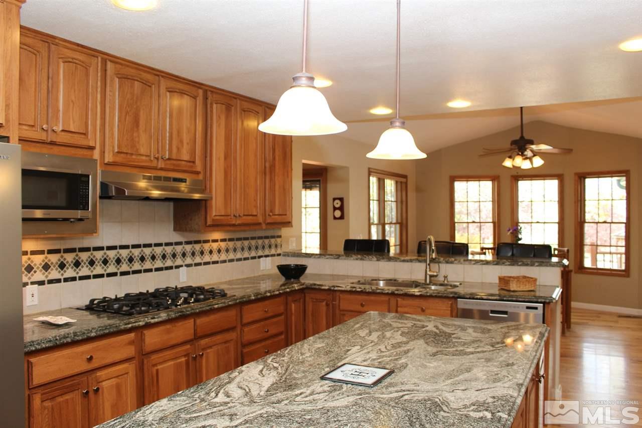 4195 Juniper Creek Road Reno, NV 89519 - Photo 1 of 1 a large kitchen with granite countertop a stove a sink a window and dining table