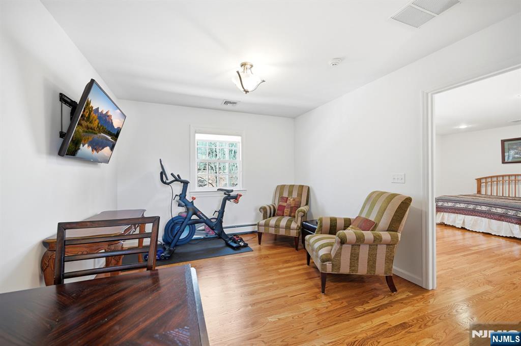 760 Rivenwood Road Franklin Lakes, NJ 07417 - Photo 17 of 48 a living room with furniture a flat screen tv and gym equipment