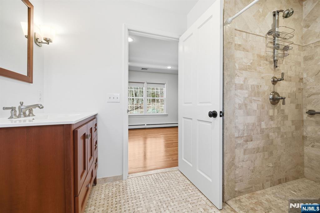 760 Rivenwood Road Franklin Lakes, NJ 07417 - Photo 21 of 48 a bathroom with a granite countertop sink a mirror and shower