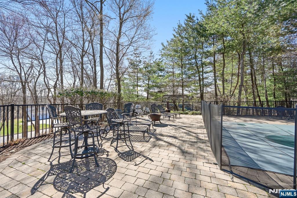 760 Rivenwood Road Franklin Lakes, NJ 07417 - Photo 47 of 48 a view of a patio with a dining table and chairs with wooden floor and fence