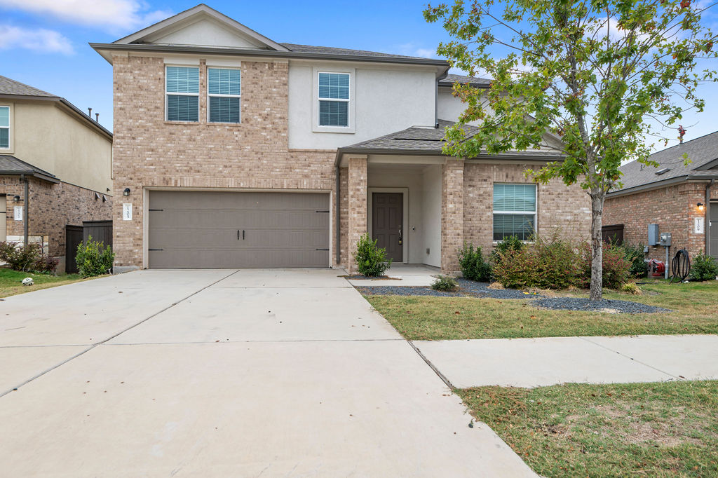 1205 Sweetspire Street Leander, TX 78641 - Photo 2 of 31 Traditional-style house with brick siding, concrete driveway, a front lawn, and a garage