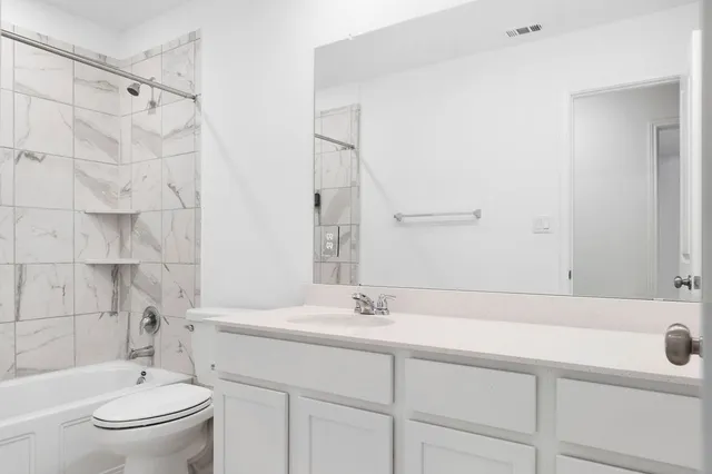 a bathroom with a sink toilet a mirror and shower