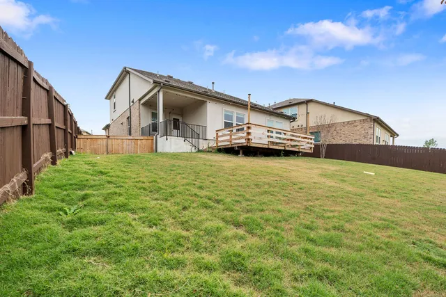 a view of a house with a big yard and large trees