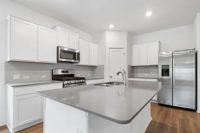 a kitchen with stainless steel appliances granite countertop a sink a stove and microwave