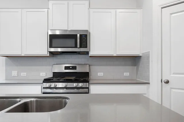 a kitchen with stainless steel appliances granite countertop a sink and a stove