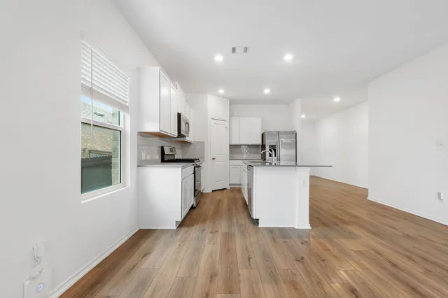 a kitchen with a refrigerator and a stove top oven